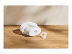 White plastic filter housing and a small clear plastic part on a wooden surface.