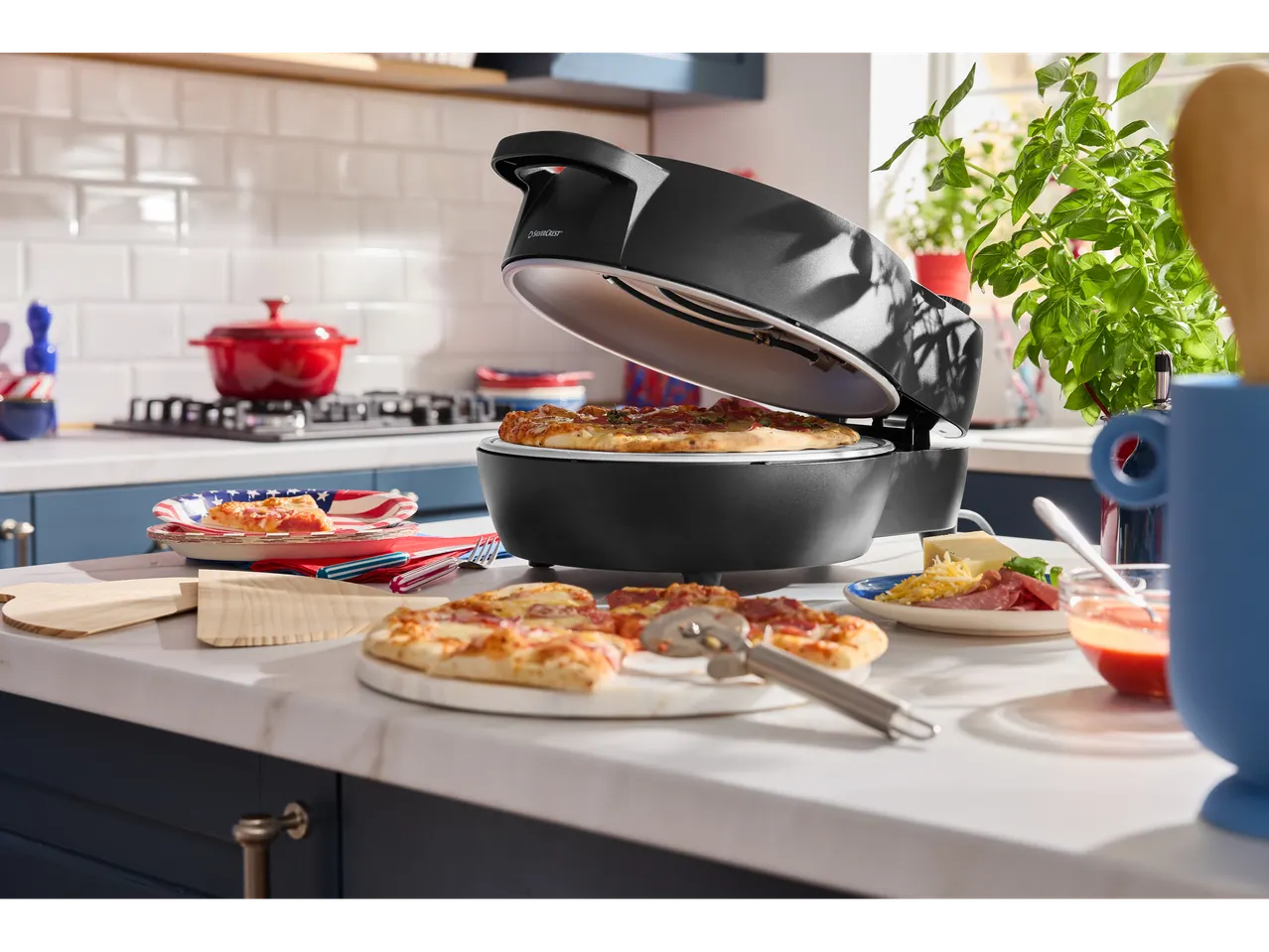 Cuptor electric de pizza Silvercrest® cu capac deschis coacând o pizza, înconjurat de accesorii.