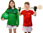 Two kids in sports jerseys, one holding a green Gaelic football, the other a hurley stick.