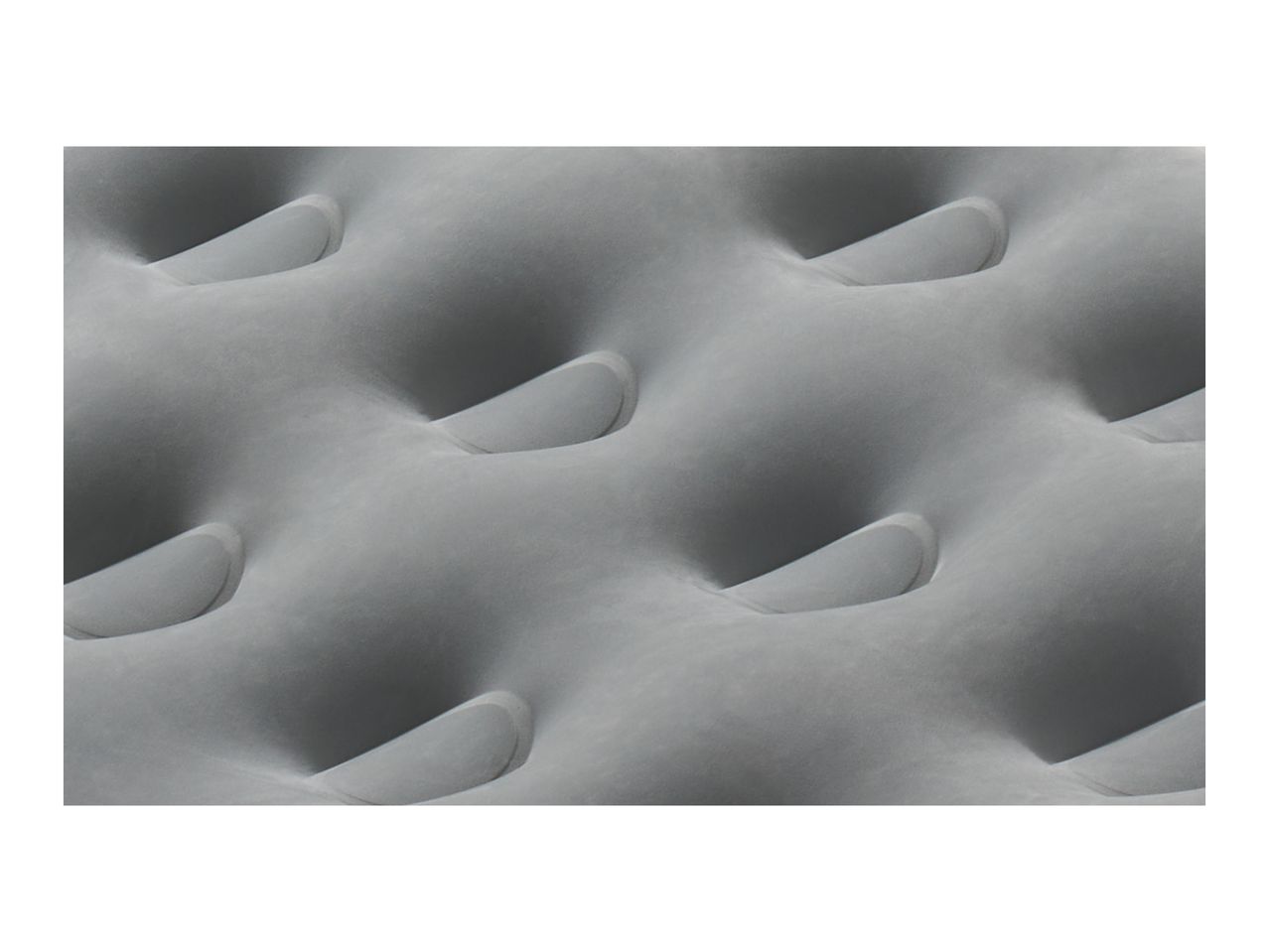 Close-up of a grey inflatable air mattress with a textured, dimpled surface.