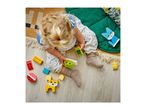 Overhead view of a baby playing with colorful building blocks on a wooden floor.