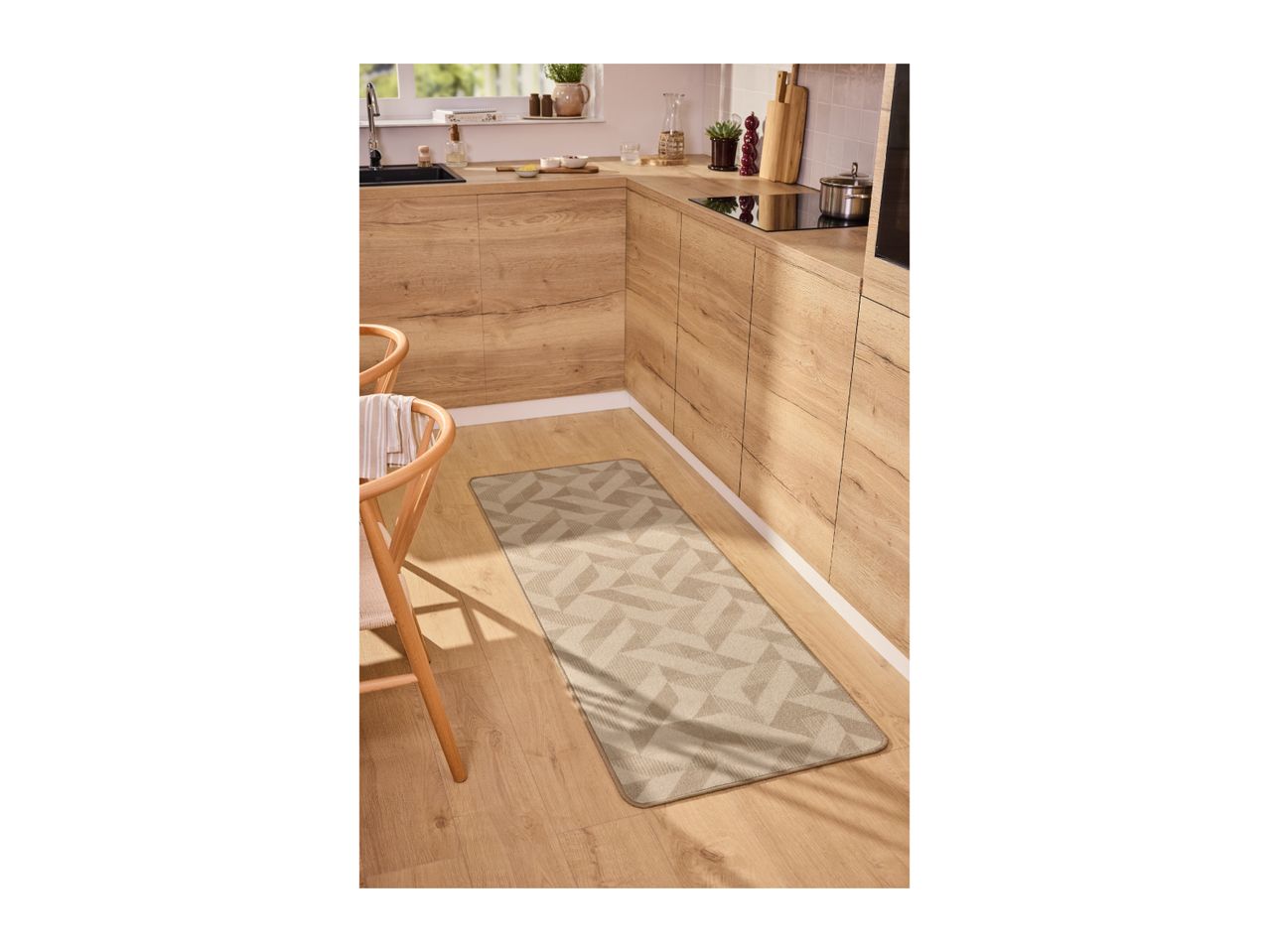 Geometric patterned kitchen runner rug on a light wood floor in a modern kitchen.