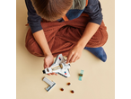 Child playing with a toy space shuttle on a light background.