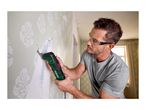 Man wearing safety glasses and earplugs, using a multi-tool to remove wallpaper.
