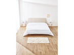 Modern bedroom with white duvet, nightstands, and rug.