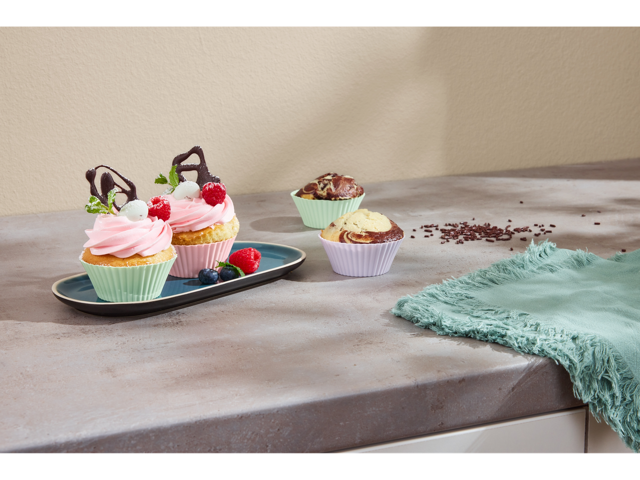 Deliciosos cupcakes e muffins decorados numa bancada de cozinha.