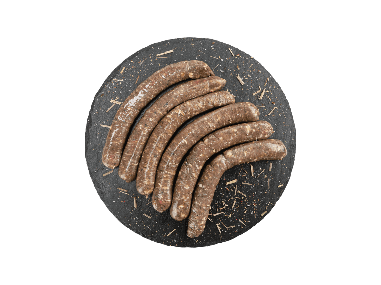 Žalios dešrelės su prieskoniais ant juodos apvalios lentelės