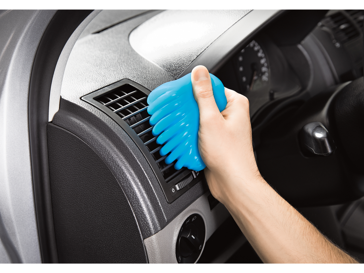 Käsi puhastab auto ventilatsiooniavasid sinise puhastusgeeliga.