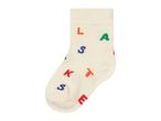 A single cream-colored sock with colorful letters 