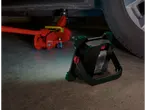 Lampă de lucru LED Parkside® și cric roșu sub o mașină