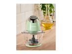 A SilverCrest food chopper on a wooden counter with a bottle of oil and plant in the background.
