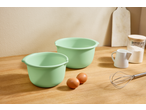 Dve zelene Zenker® posude za mešanje, jaja, brašno i žica na drvenoj radnoj ploči.