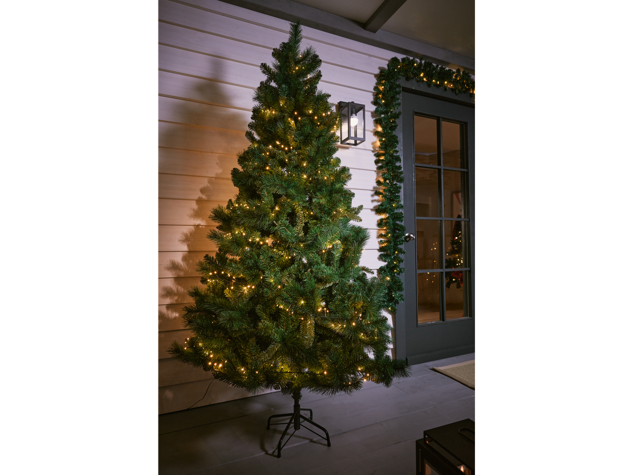 LIVARNO home 580 LED Galaxy String Lights on a Christmas tree and garland outdoors.