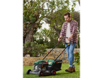 Man using a Parkside lawnmower in a garden.