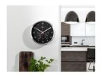 A black wall clock with temperature and humidity gauges in a modern kitchen.