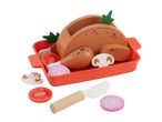 Wooden toy roast chicken in a red baking dish with vegetable slices and a toy knife.