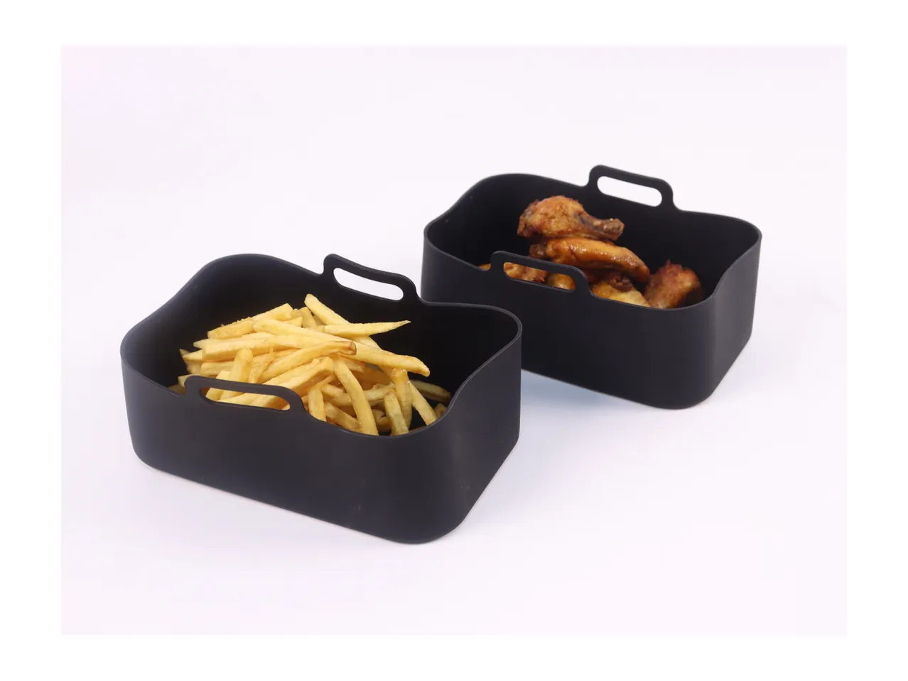 Two black silicone air fryer baskets, one with fries and one with chicken wings.