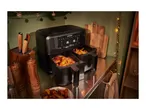 A black SilverCrest dual air fryer cooking chicken wings and potato wedges.