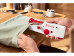 Person using a white and red Singer handheld sewing machine on light green fabric.