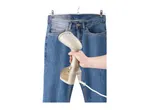 Handheld garment steamer being used on blue jeans hanging on a hanger.