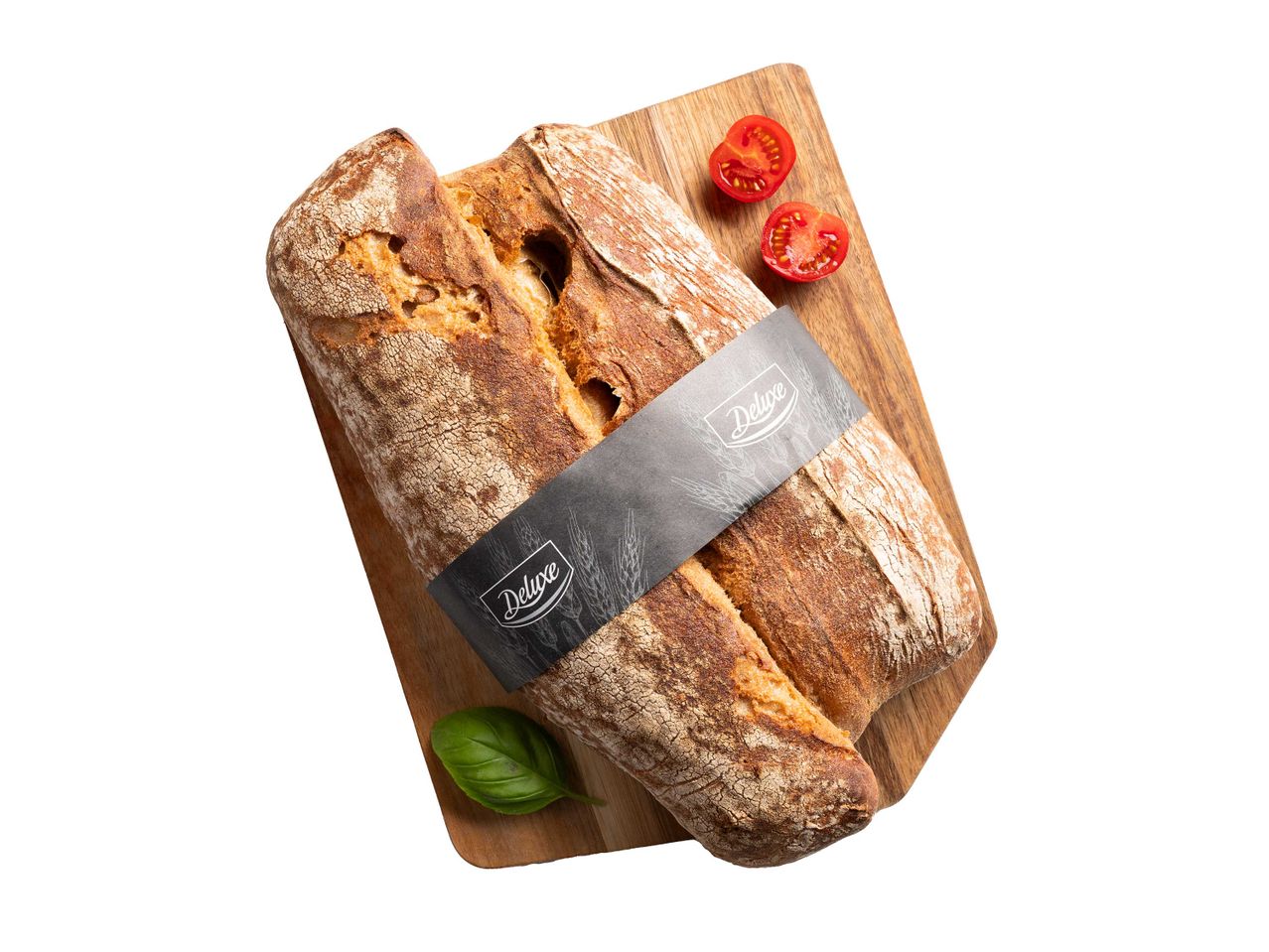 Két bagett egy vágódeszkán, paradicsommal és bazsalikommal.