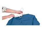 Hands placing a blue cardigan onto a white clothes hanger.