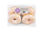 Vier party donuts met kleurrijke sprinkles in een plastic bakje.