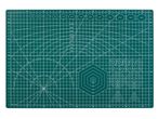 A green cutting mat with various measurements, angles, and shapes for crafting.
