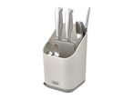 A white Joseph Joseph knife block holds several knives.
