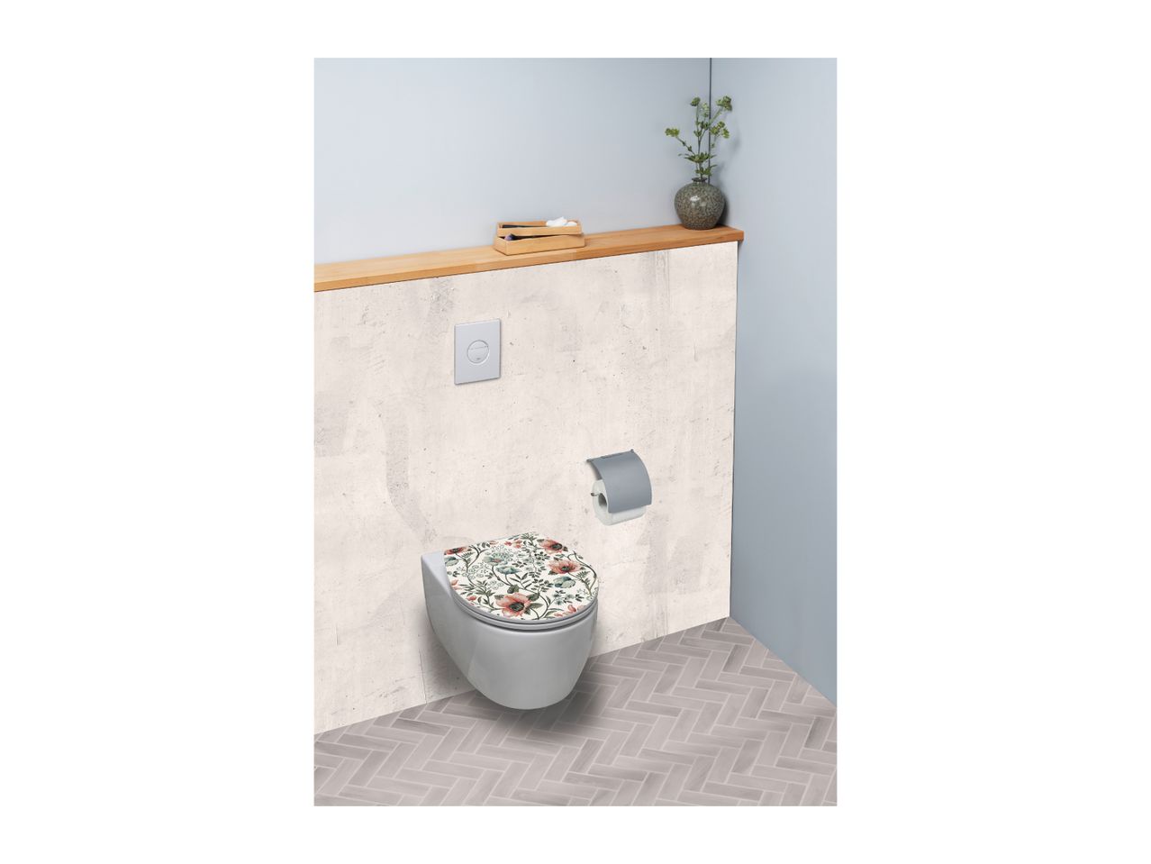 Toilet with a floral patterned seat, toilet paper holder, and a wooden shelf with decor.