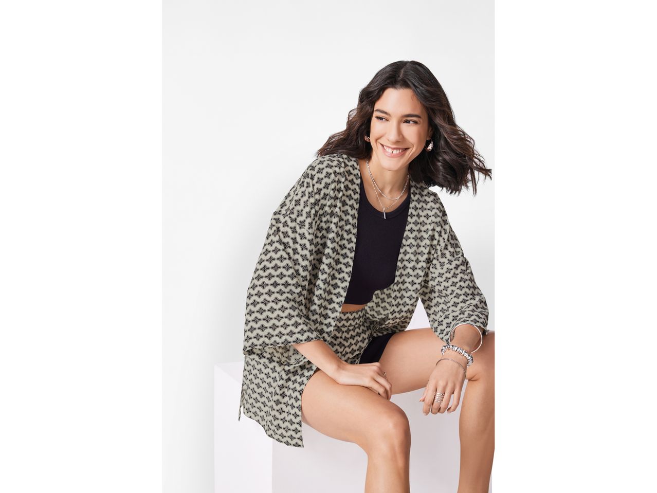 Woman wearing a patterned kimono-style jacket and matching shorts.