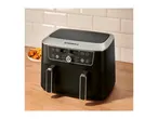 Black dual air fryer with digital display showing 180°C, next to a plate of chicken wings and fries.