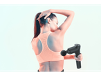 Woman using a black massage gun on her back.