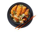 Sesame chicken tenders served over rice with vegetables and sweet chili sauce.
