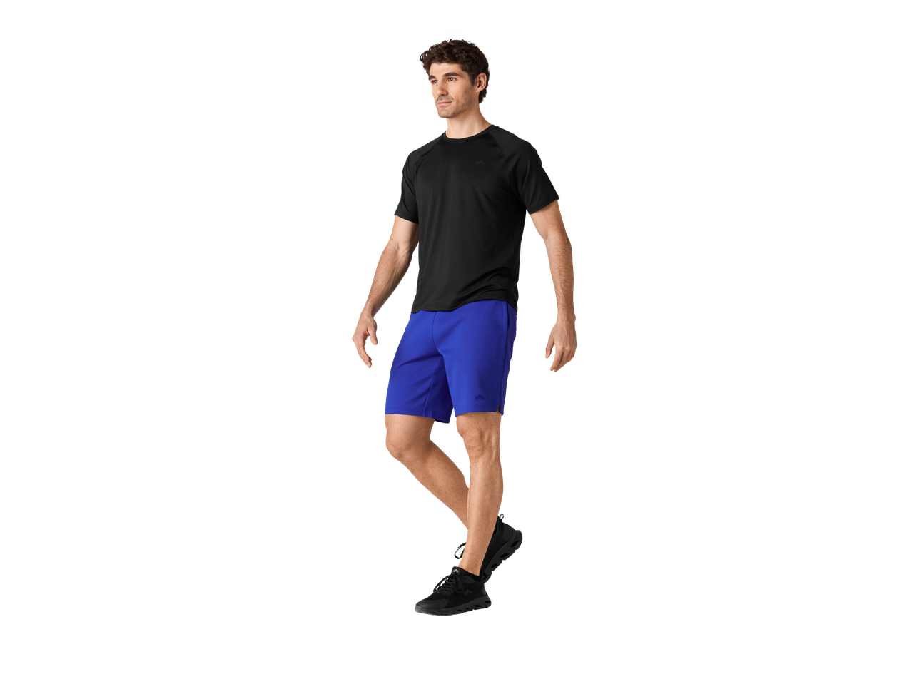 Muškarac u plavim šortsicama i crnoj majici.