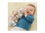 Smiling baby in blue top holding a plush otter toy on a fluffy rug.
