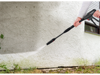 A person cleans a wall with a Parkside pressure washer.