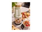 Silvercrest food chopper with nuts and seeds, next to a bowl of fruit and cereal.
