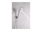 Chrome shower head spraying water against a light gray tiled wall.