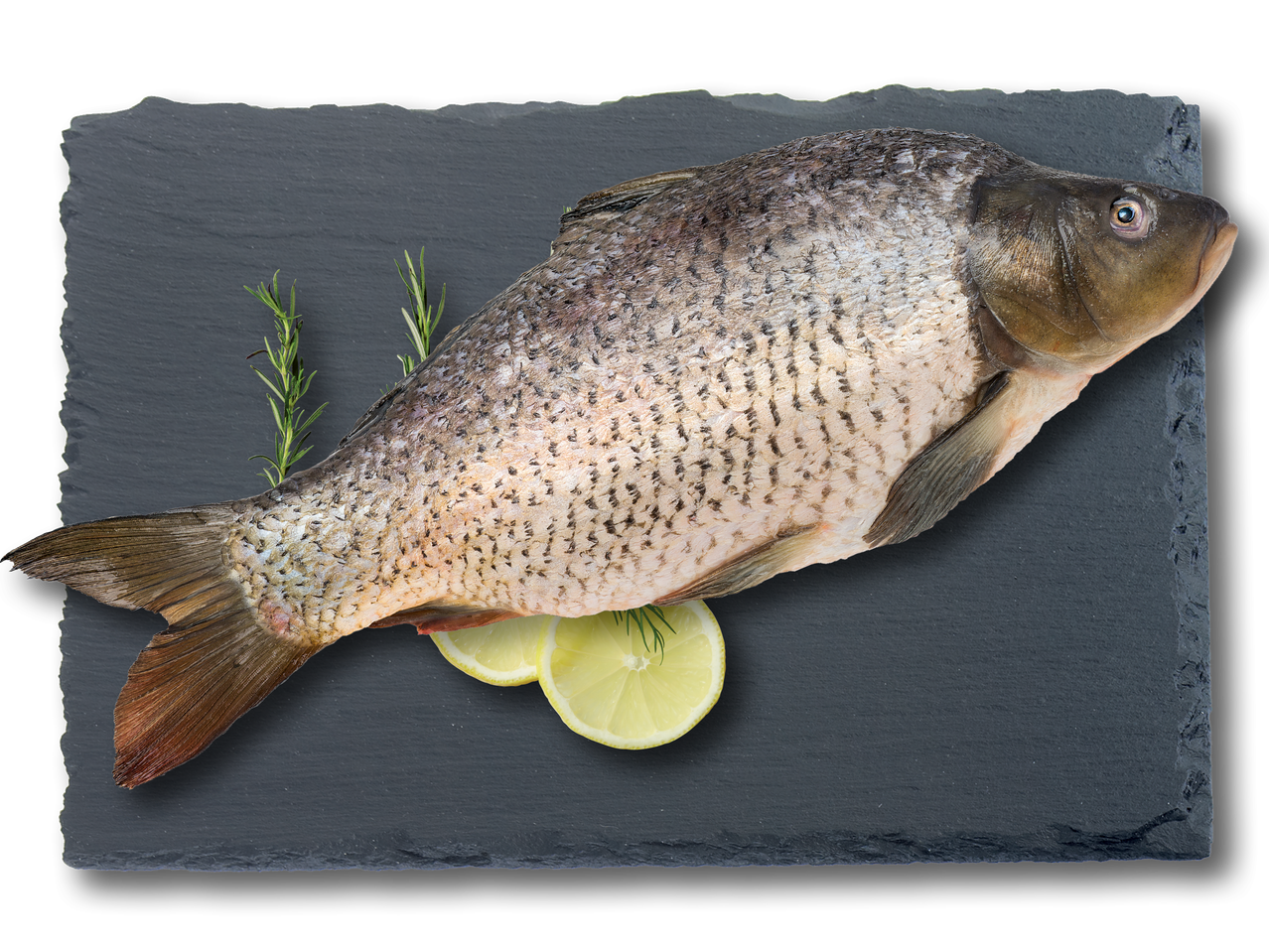 Цял шаран с розмарин и резени лимон върху черна шистова дъска.