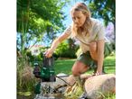 Woman placing a submersible pump into a pond, with water splashing.