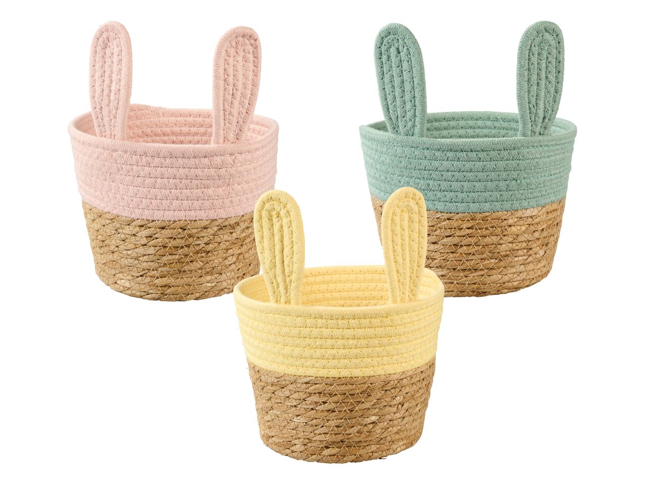 Drei geflochtene Körbe in Pastellfarben mit Hasenohren