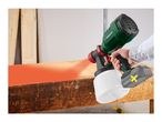 A person spray painting a wooden surface with an electric paint sprayer.