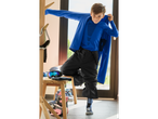 Boy wearing CRIVIT Kids' Seamless Base Layer Set and ski pants, getting ready for skiing.