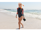 CRIVIT Ladies' Aqua Shoes held by a woman in a rash guard on a sandy beach.