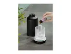 Adding essential oil to a modern black and glass aroma diffuser