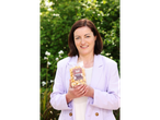 Woman holding a bag of Second Street Bakeshop Gourmet Toffee Popcorn.