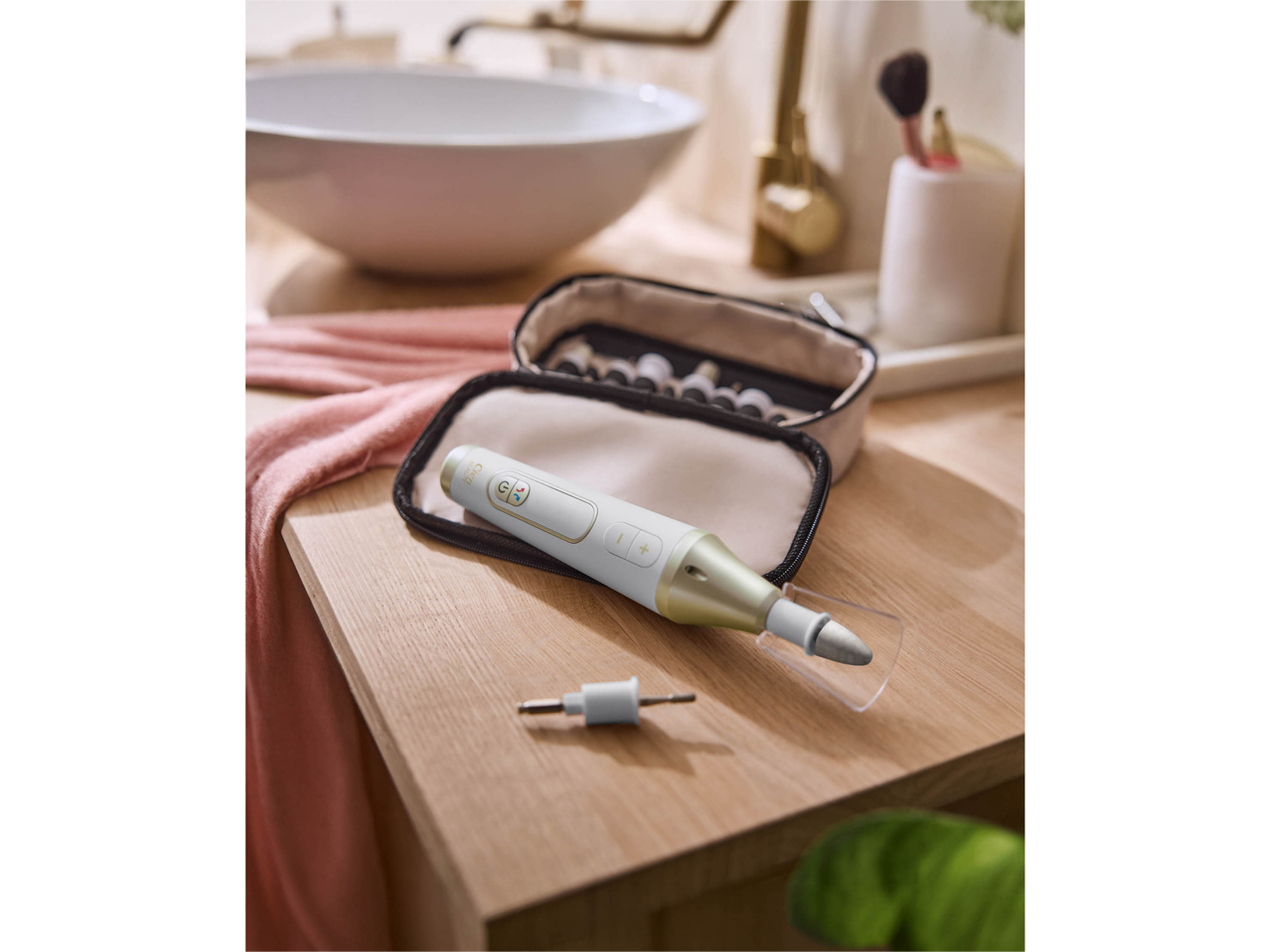 Electric nail file with accessories in a bathroom setting.
