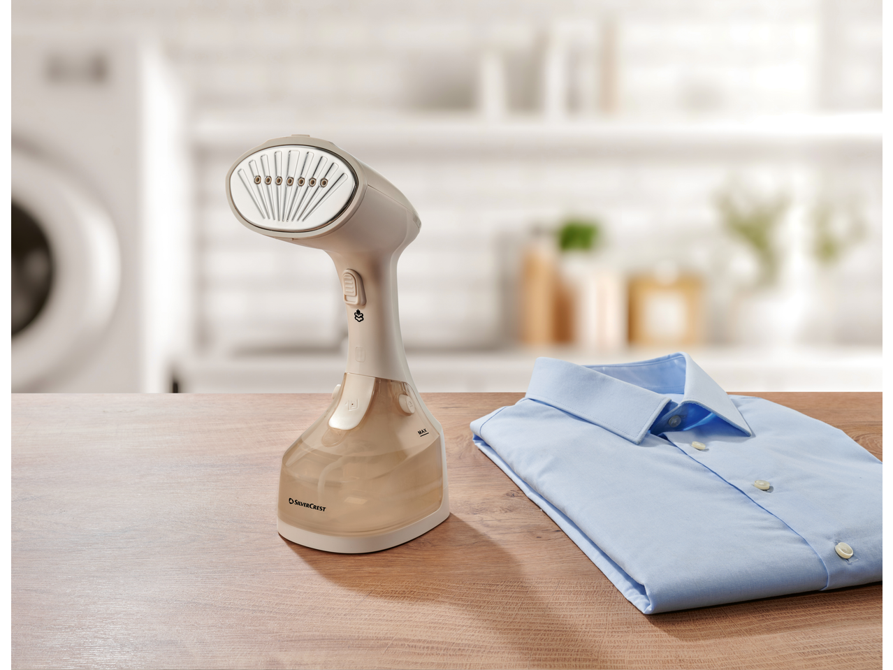 SILVERCREST® Garment Steamer and a folded blue shirt on a wooden table.