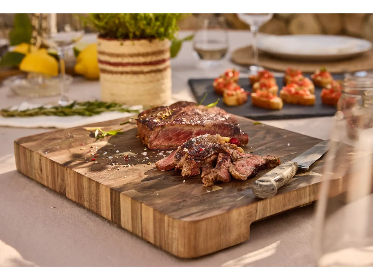 Lédús steak, szeletelve egy fa vágódeszkán, falatkák társaságában.